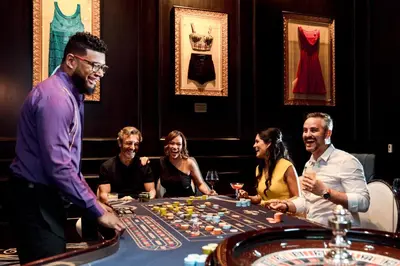 a group of people sitting around a table playing roulette at Hard Rock Hotel & Casino Punta Cana - All Inclusive in Punta Cana