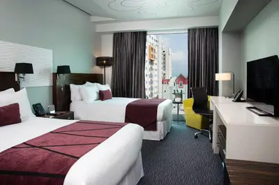 a hotel room with two beds and a television at Holiday Inn Santo Domingo by IHG in Santo Domingo