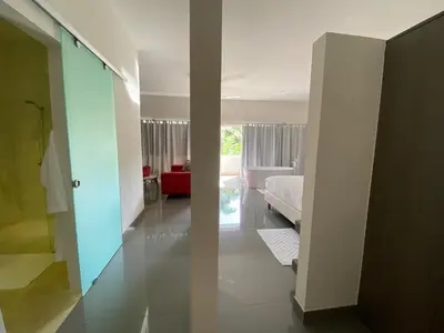 a bedroom with a bed and a living room at CASA-22 Luxury Boutique Hotel in Sosúa