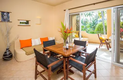 a living room with a wooden table and chairs at Hotel Alisei in Las Terrenas