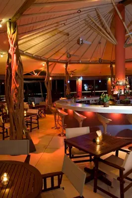 a restaurant with tables and chairs and a bar at Hotel Alisei in Las Terrenas