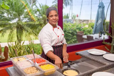 a woman is preparing food on a counter at Hotel Alisei in Las Terrenas