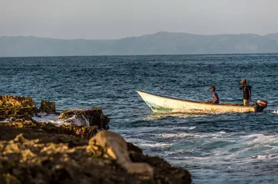 two people in a boat in the water at The Cove Apartments in El Francés