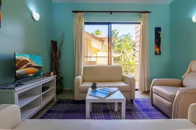 a living room with a couch and a tv at D'Piero Hotel in Sosúa