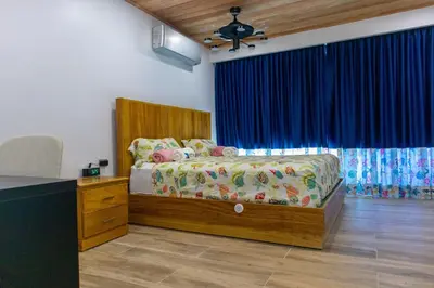 a bedroom with a bed with a blue curtain at Villa Elegante y Familiar en Pedernales, Cerca de la Playa del pueblo, Residencial SFA in Pedernales