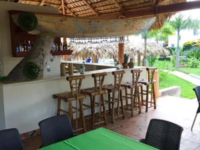a bar in a restaurant with chairs and a table at Las Galeras Hotel in Las Galeras