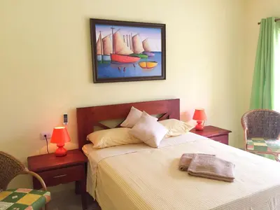 a bedroom with a bed with two tables and two lamps at Las Galeras Hotel in Las Galeras