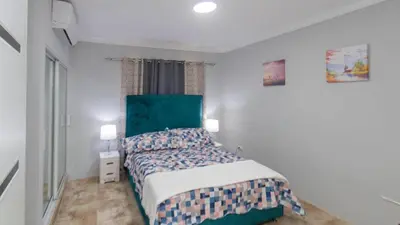 a bedroom with a bed with a green headboard at Nely y Pietro share apartment in Punta Cana