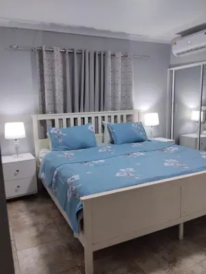 a bedroom with a bed with blue sheets and blue pillows at Nely y Pietro share apartment in Punta Cana