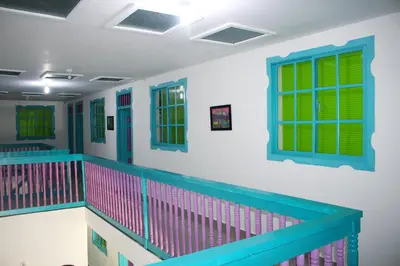 a room with a balcony with green and pink windows at Hostal Johnnier Macao Punta Cana in Punta Cana