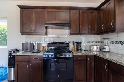 a kitchen with wooden cabinets and a stove at House 24 in Casa Linda in Sosúa