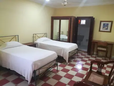two beds in a room with a checkered floor at Villa Carolina Bed and Breakfast in San Felipe de Puerto Plata