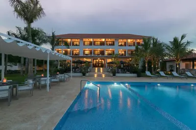 a hotel with a swimming pool in front of a building at Hotel Casa Hemingway in Juan Dolio