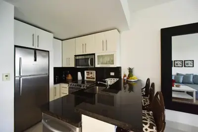 a kitchen with a black counter top and a refrigerator at Seawinds Studio - Beachfront Getaway in Cabarete