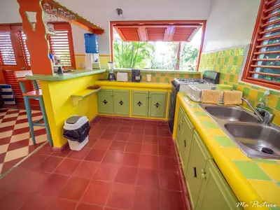 a kitchen with yellow and green cabinets and a sink at Résidence Villas Les Hibiscus in Las Terrenas