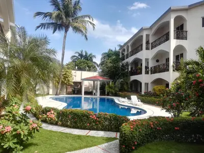 a resort with a swimming pool in front of a building at Apartamento en Las Terrenas in Las Terrenas