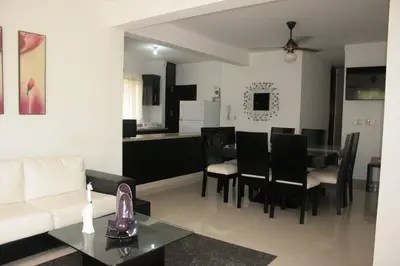 a living room with a white couch and a table at Residencial Vista Del Bosque in Santiago de los Caballeros