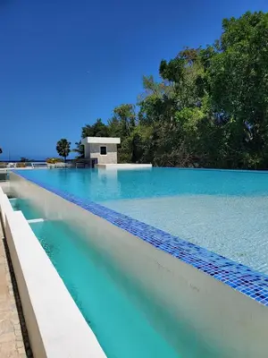 a pool of blue water with a building in the background at Susy paradise in Sosúa