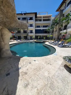 a swimming pool in front of a building at Susy paradise in Sosúa