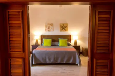 a bedroom with a bed with two lime green pillows at Tot Punta Cana Apartments in Punta Cana