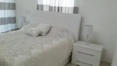a bedroom with a white bed with two pillows on it at White House Mansion in San Felipe de Puerto Plata