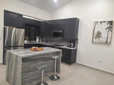 a kitchen with a wooden island in the middle at White House Mansion in San Felipe de Puerto Plata