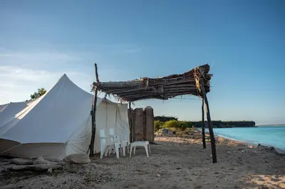 a tent and chairs on a beach next to the water at Eco Del Mar in Pedernales