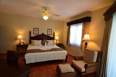 a bedroom with a large bed and a chair at Cofresi Palm Beach & Spa Resort - All Inclusive in San Felipe de Puerto Plata