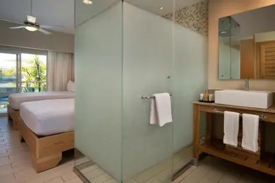 a bathroom with a shower and a bed and a sink at Lifestyle Tropical Beach Resort & Spa All Inclusive in San Felipe de Puerto Plata