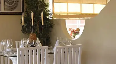 a dining room with a table with white chairs and a dining roomiasm at Lifestyle Crown Residence Suites in San Felipe de Puerto Plata