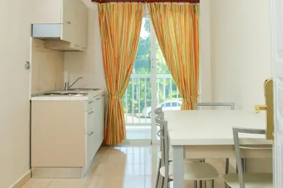 a kitchen with an orange curtain and a table and a window at Kitewind Apartamentos Cabarete in Cabarete