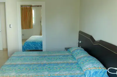 a bedroom with a bed with a blue comforter at Kitewind Apartamentos Cabarete in Cabarete