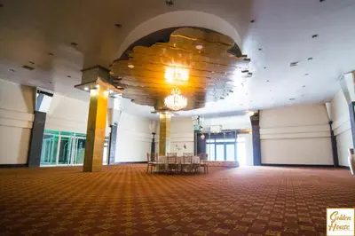 a large room with tables and a chandelier at Golden House Hotel & Convention Center in Santo Domingo
