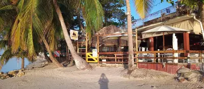 a building on the beach with palm trees at The Boat House in Boca Chica