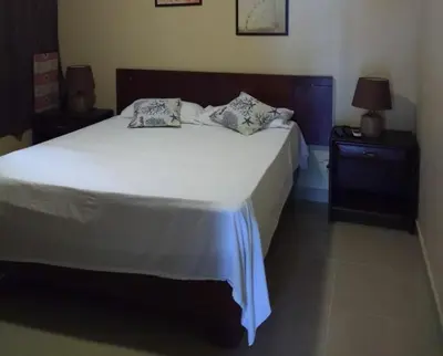 a bedroom with a large white bed and a nightstand at The Boat House in Boca Chica
