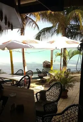 a table and chairs with umbrellas on a beach at The Boat House in Boca Chica