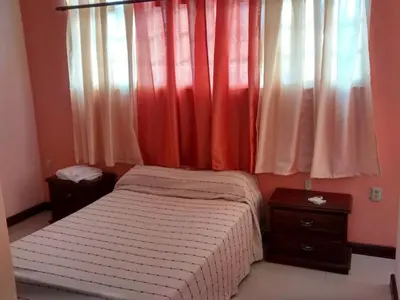 a bedroom with a bed and a window with curtains at The Boat House in Boca Chica