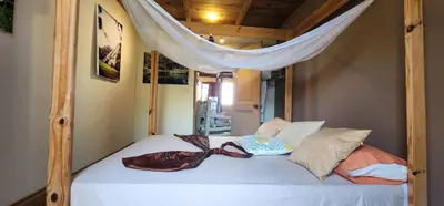 a bedroom with a bed with a canopy and pillows at Tropic ecolodge in Punta Rucia