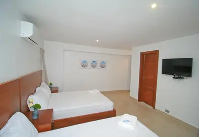 a hotel room with two beds and a flat screen tv at Palmetto Hotel in Santiago de los Caballeros