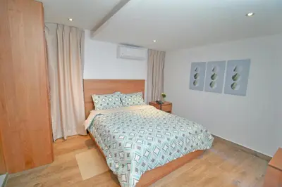 a bedroom with a bed and a wooden floor at Palmetto Hotel in Santiago de los Caballeros
