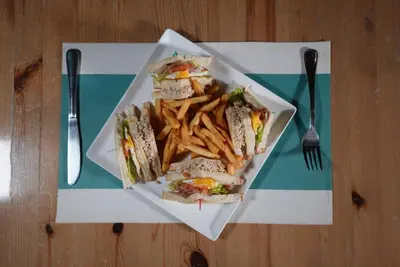 a plate of sandwiches and french fries on a table at Hotel Agua Dulce in Boca Chica