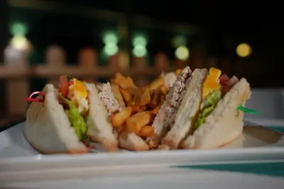 a white plate with a sandwich and french fries at Hotel Agua Dulce in Boca Chica