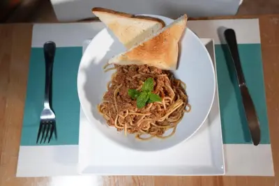 a plate of spaghetti and toast on a table at Hotel Agua Dulce in Boca Chica