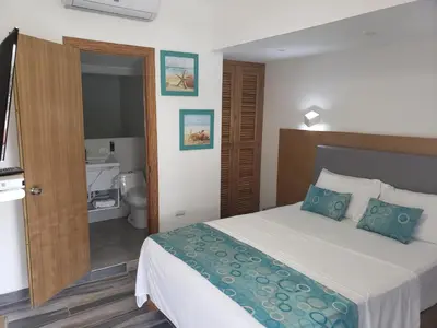 a hotel room with a bed and a bathroom at Hotel Agua Dulce in Boca Chica