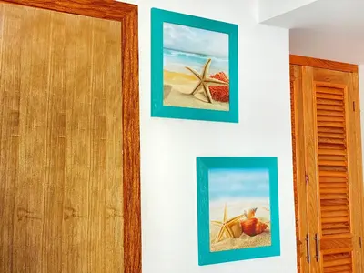 two pictures of a beach and a starfish on a wall at Hotel Agua Dulce in Boca Chica