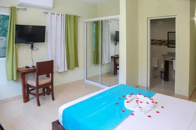 a bedroom with a bed and a desk and a television at Anton Reef in Sosúa