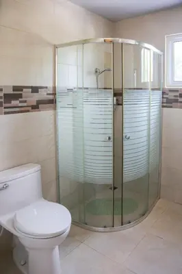 a bathroom with a glass shower with a toilet at Anton Reef in Sosúa