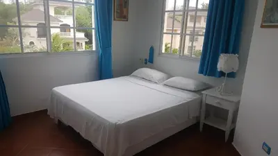 a bedroom with a bed and two windows at Hispaniola Residencial private villas in Sosúa