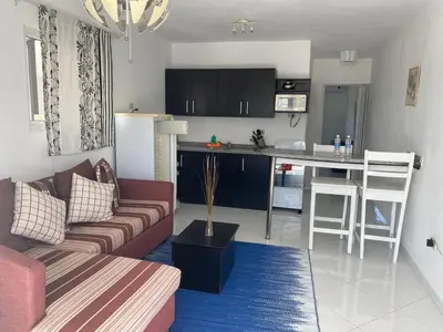 a living room with a couch and a kitchen at El Cabarete Spa Resort all-Inclusive in Cabarete