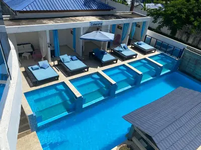 an overhead view of a pool with chairs and an umbrella at El Cabarete Spa Resort all-Inclusive in Cabarete